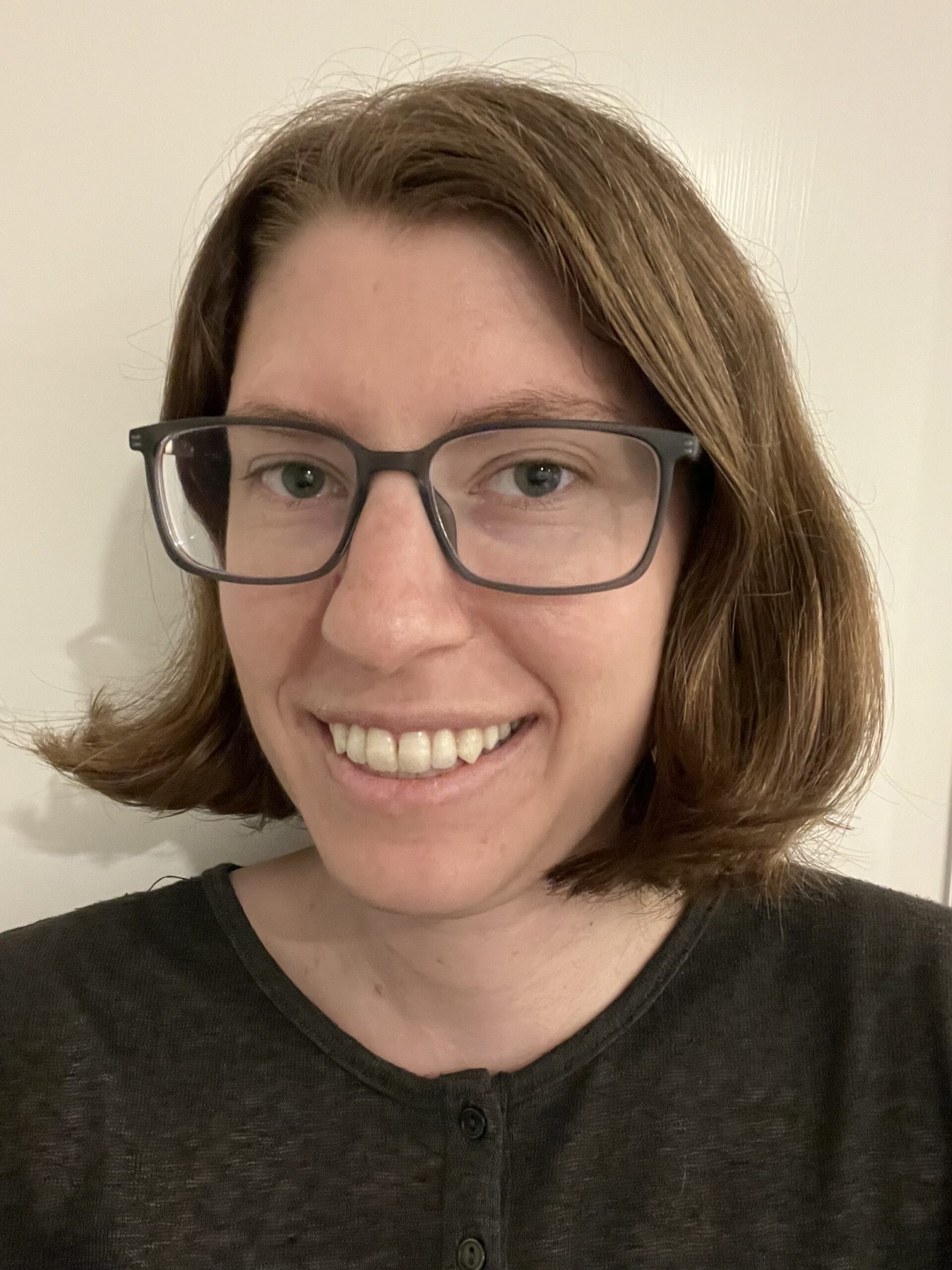 Headshot of Alison King against a beige wall.