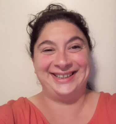 Crystia Peter, story contributor, wearing a salmon-colored top and standing in front of a neutral background.