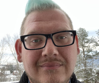 Dominick Halse, story contributor, standing outside with trees in the background.