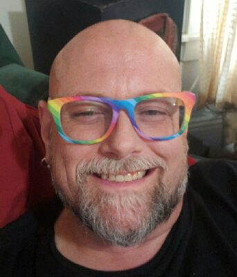 Gregory Broyles, story contributor, wearing rainbow-colored frames.