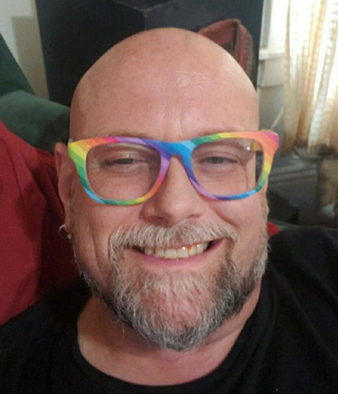 Gregory Broyles, story contributor, wearing rainbow-colored frames.