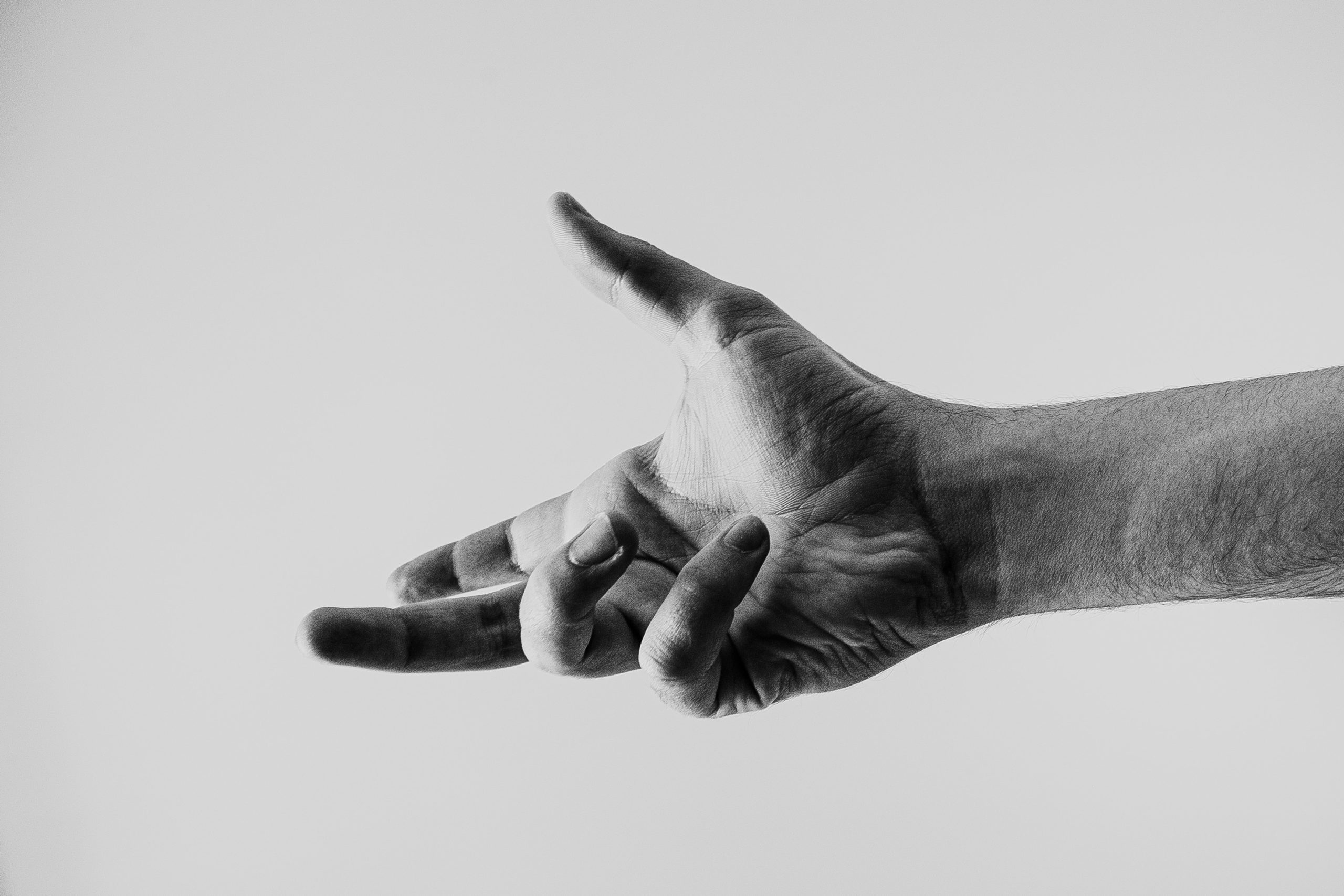 Black and white photo of an encouraging hand reaching out.