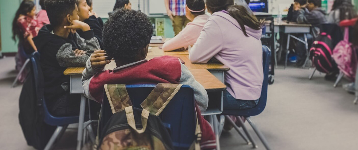 Young students in a classroom engaged in a lesson from a teacher.