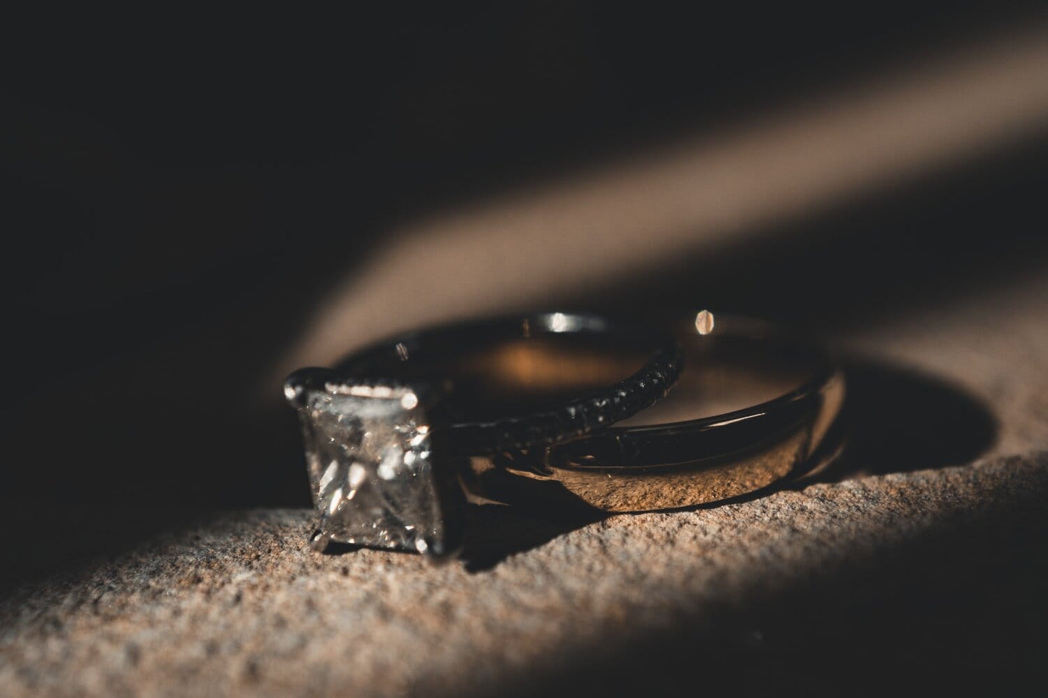 Close-up of a wedding and engagement ring stacked on each other.