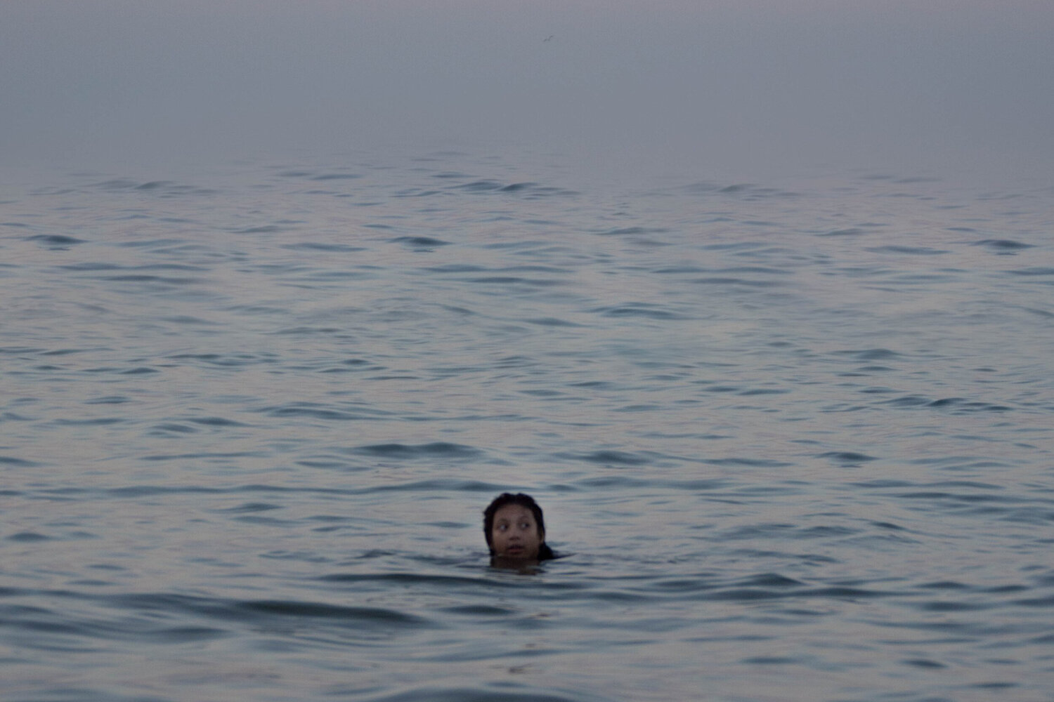 Person swimming alone in the ocean.