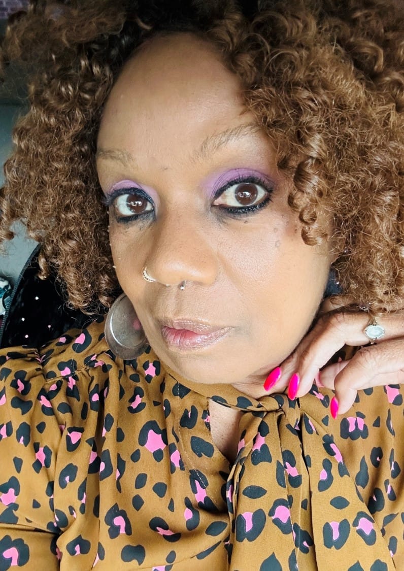 Yolanda Morrissette, story contributor, with curly brown hair and wearing a leopard print top.
