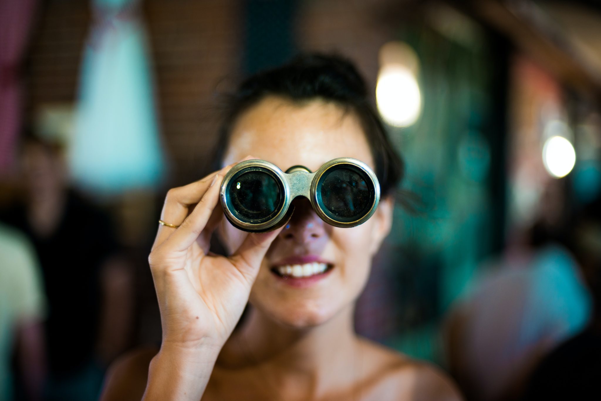 A woman looking through a pair of binoculars.