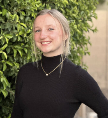 Amanda Ling outside, smiling, wearing a black top with a gold necklace.