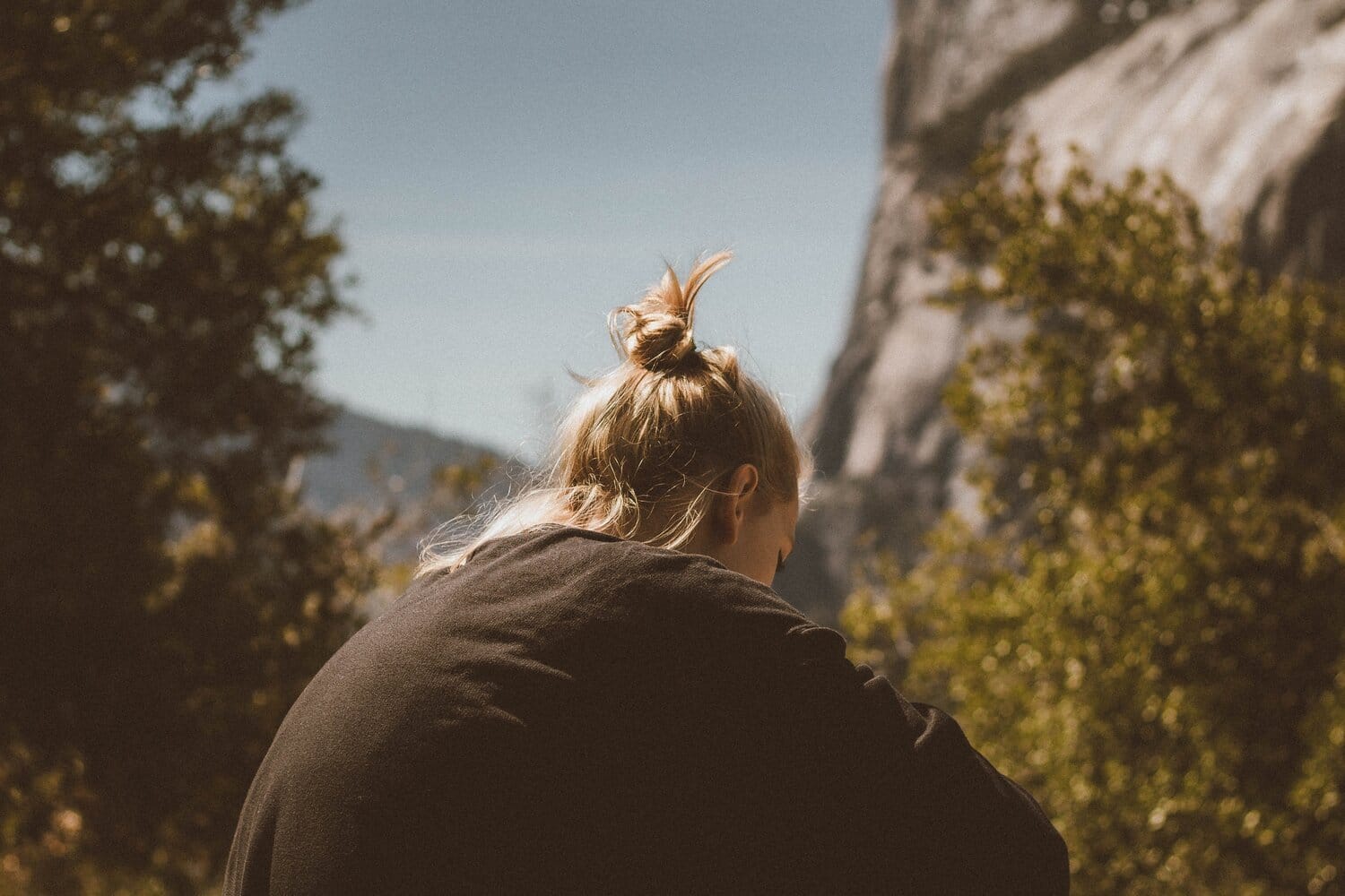 Woman sitting alone, outside with nature.
