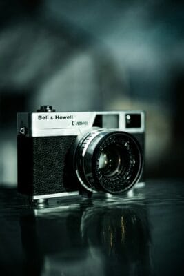 Anonymous contributor image, featuring a Canon camera on a reflective surface.