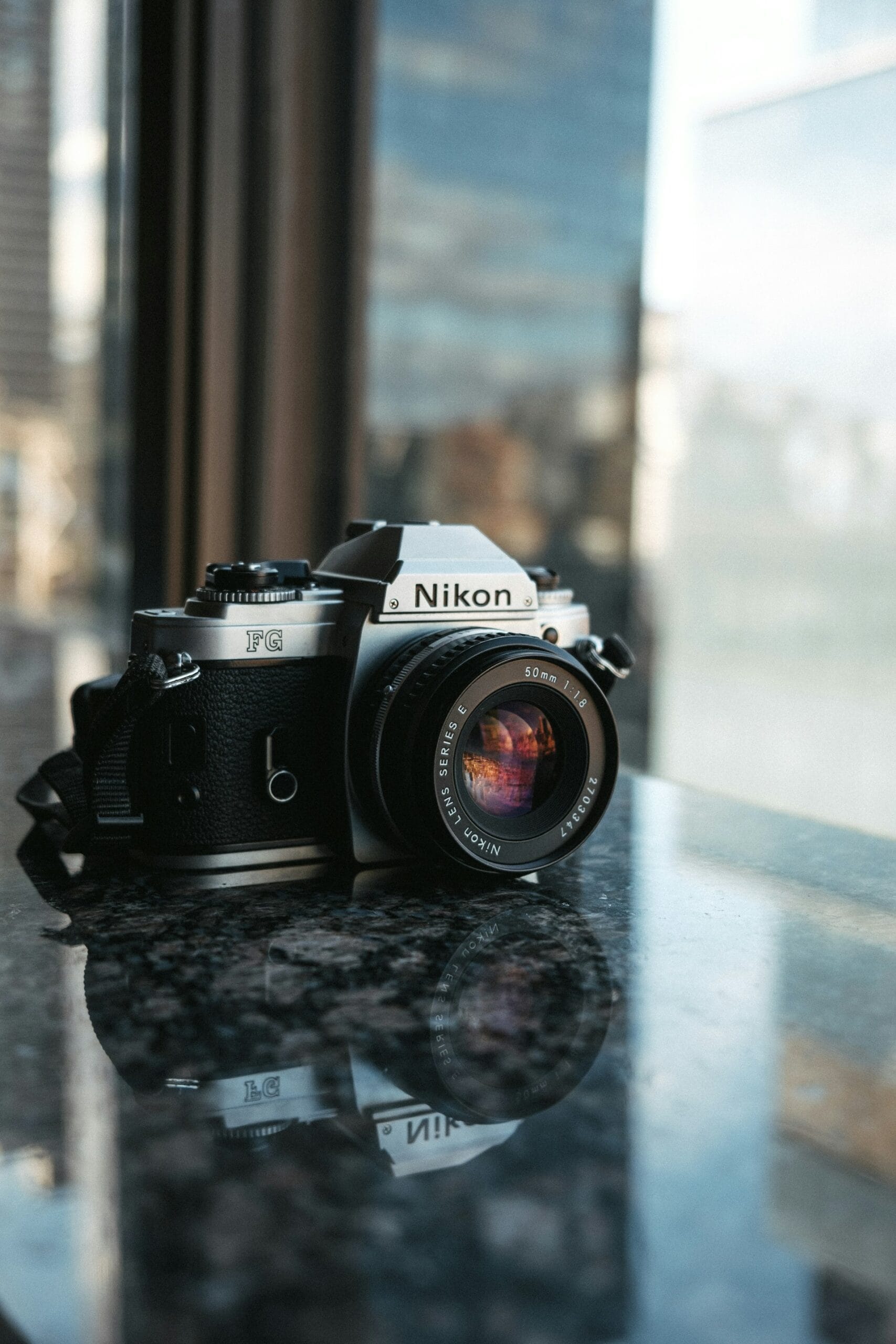 Anonymous contributor image, featuring a Nikon SLR camera on a table.