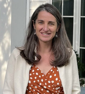 Heather Wallace, outside, with a dress and sweater.