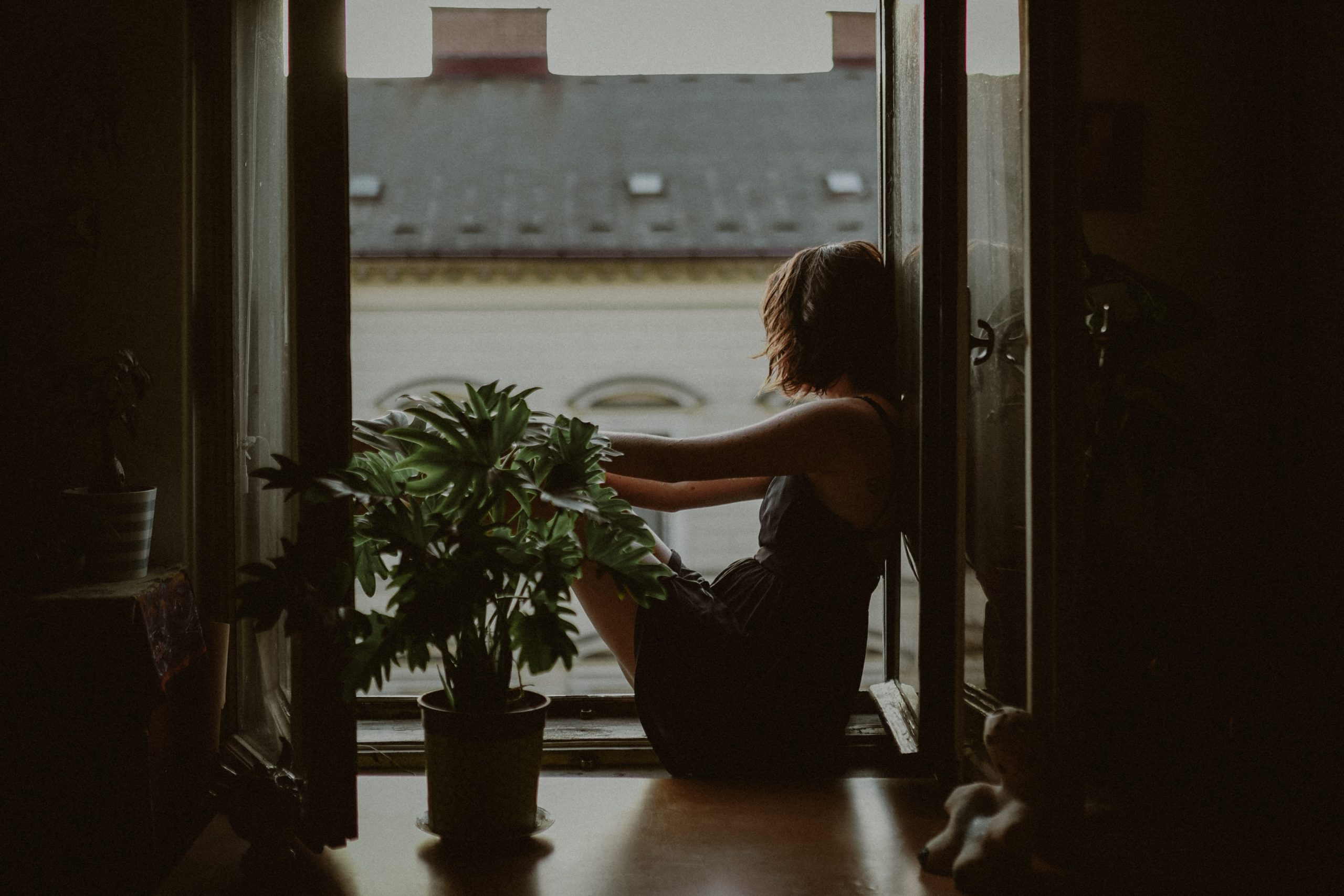 Woman sitting on the edge of a window.