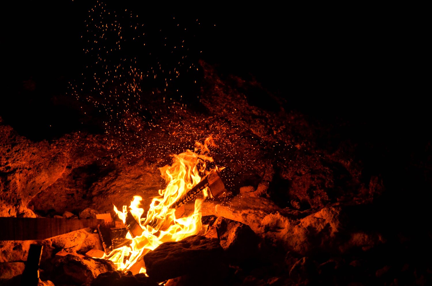 Outdoor fire at night of burning logs.