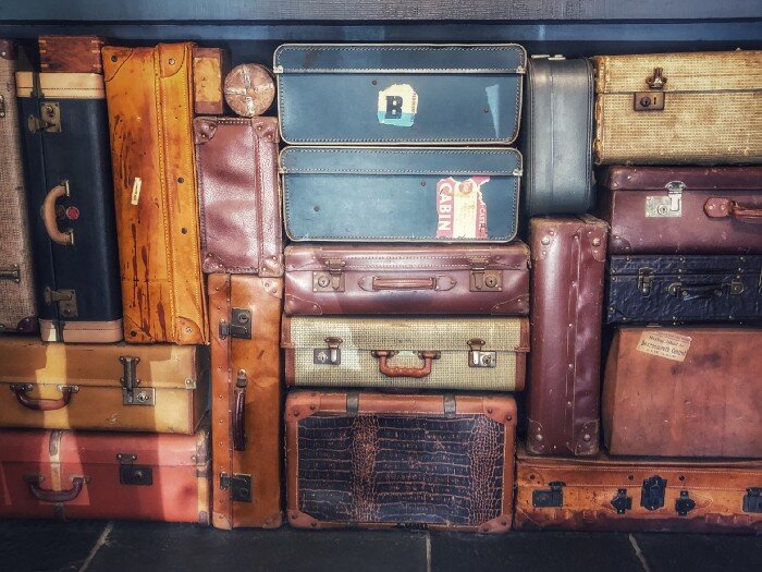 Many stacked vintage suitcases.