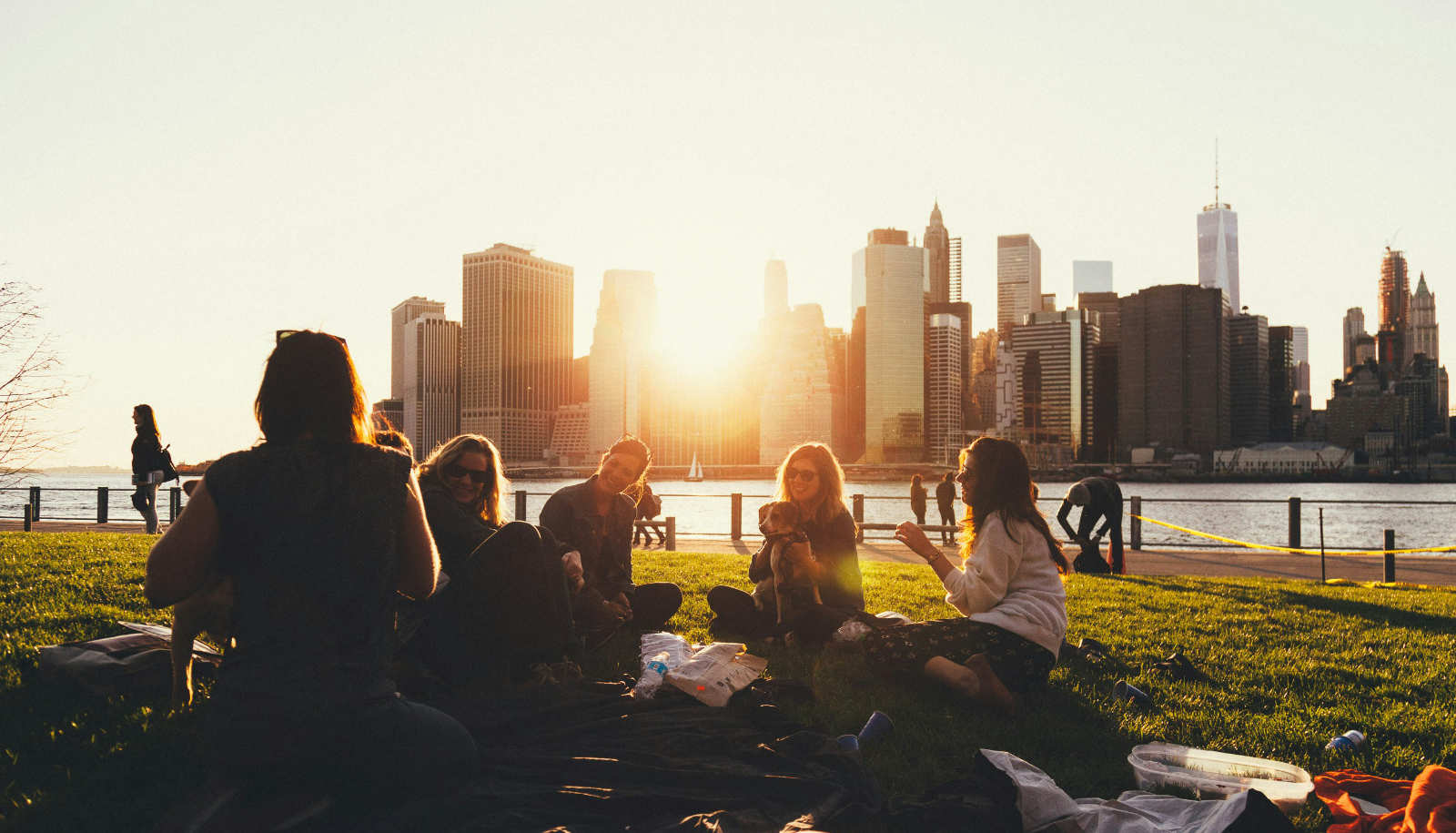 A team sitting on the grass overlooking the water.